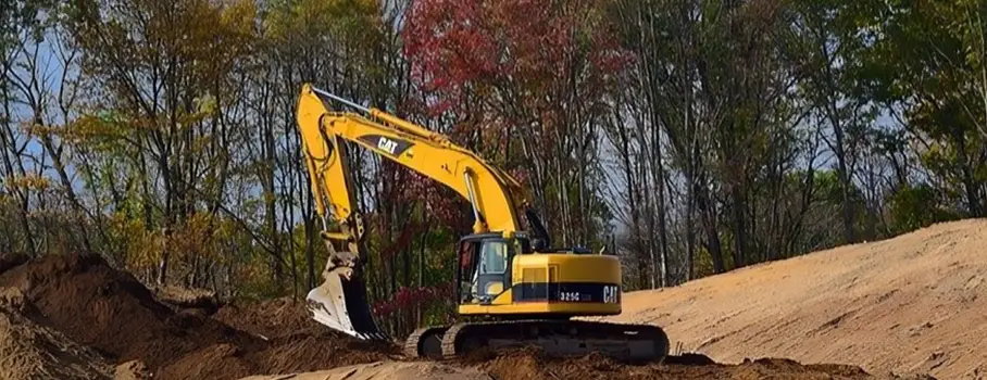 Excavator Digging on a Construction Site with Trees in the Background